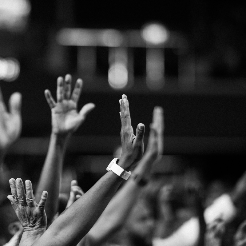 Hands raised, in a crowd.